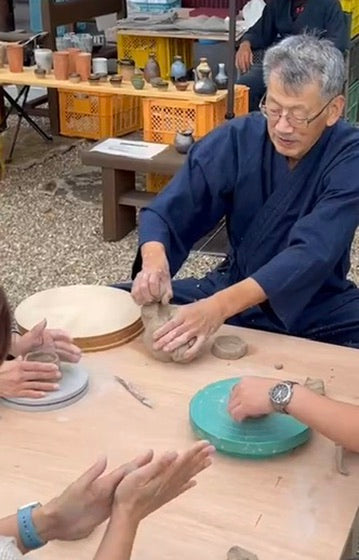 Một vị khách đang tạo hình món đồ gốm từ đất mogusa tại workshop
